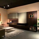 Salón con mueble modular de televisión en madera oscura, mesa de centro y alfombra